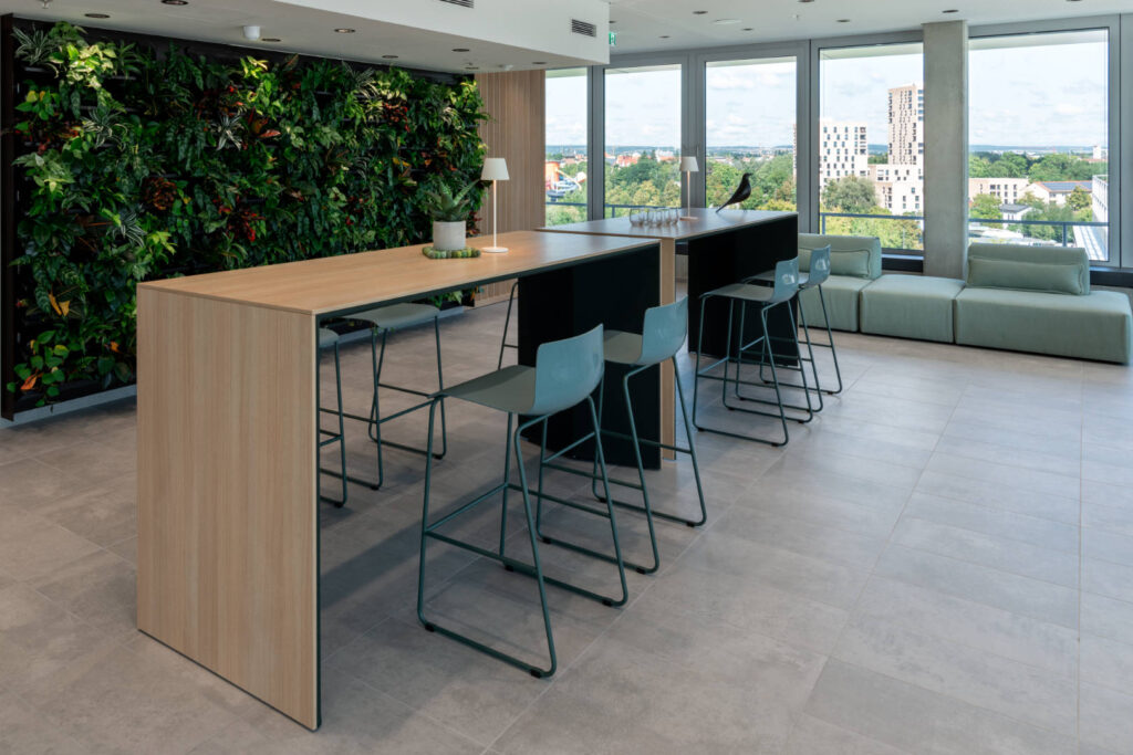 Raumansicht Cafeteria im DonauTower – Pflanzwand mit Holzlamellen kombiniert