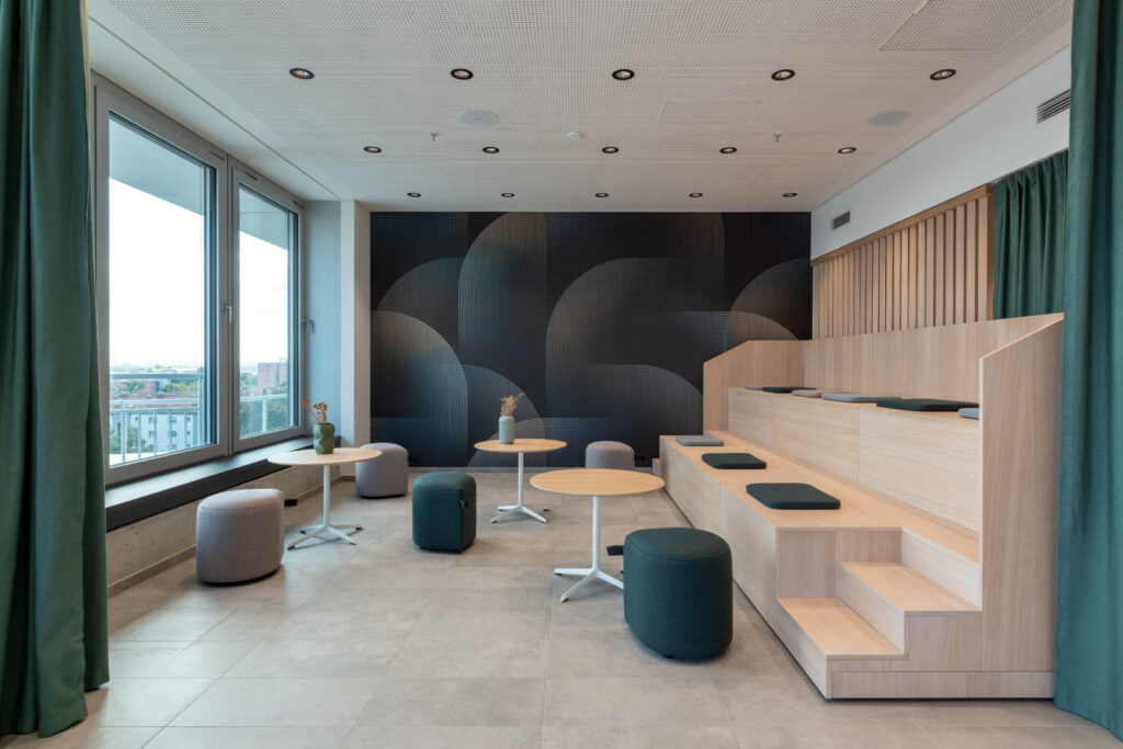 Raumansicht Cafeteria im DonauTower – Tribüne mit Holzlamellen und Akustikvorhängen