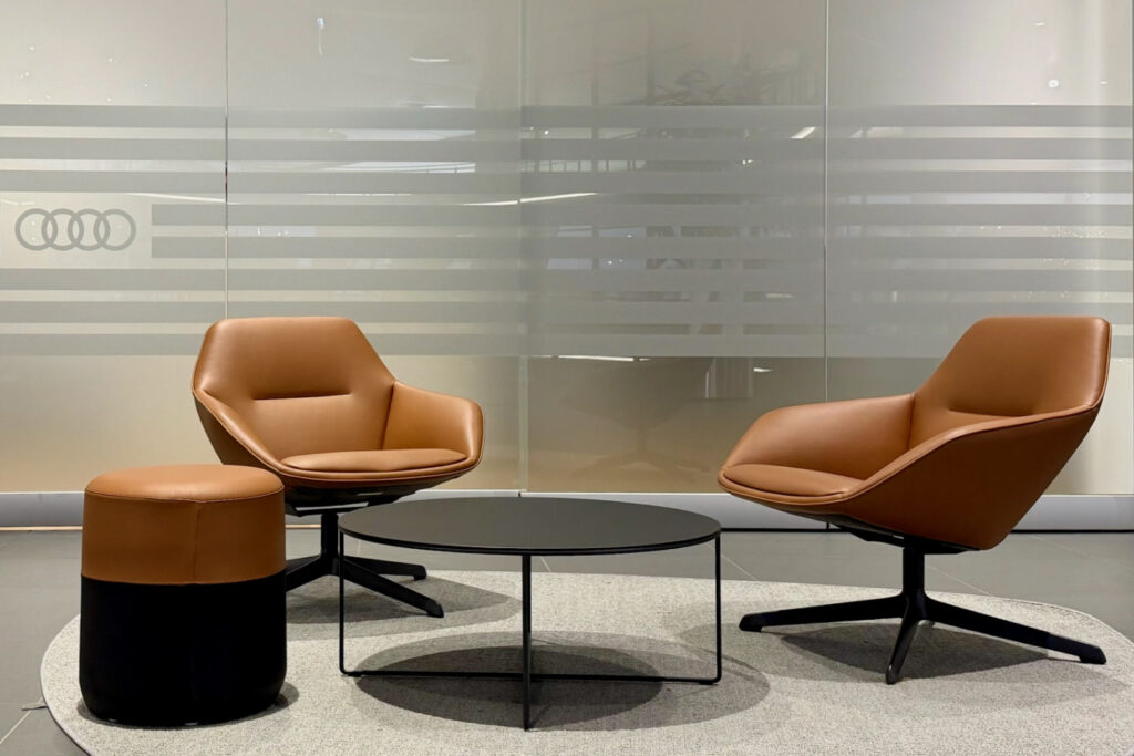 Loungebereich im Audi Forum Neckarsulm mit Sesseln und Tisch im abgestimmten Materialkonzept