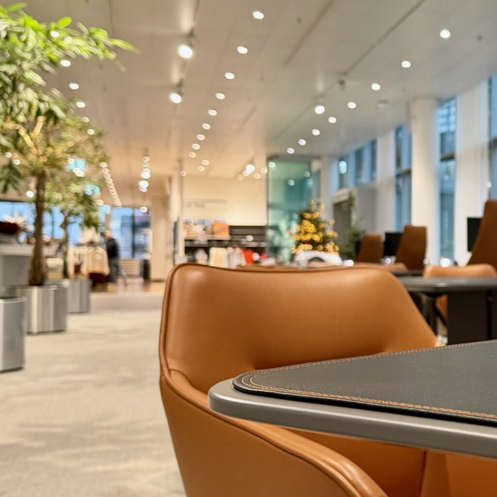 Detailaufnahme im Check-In Bereich Audi Forum Neckarsulm mit Lederstuhl und Tischoberfläche mit Kontrastnaht